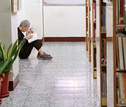 新北市立圖書館三重分館街友專注於閱讀書籍。