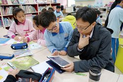 仁愛國小學生與老師討論電子資料庫上的內容。（ 林心茹提供）