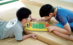 共融遊戲活動孩子體驗適合聽障、多重障礙、親子、自閉的足球機玩具。（新北市立圖書館鶯歌分館提供）