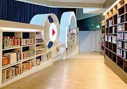 許石音樂圖書館保有舊回憶，一樓書架是下沉的育樂堂廊道空間。