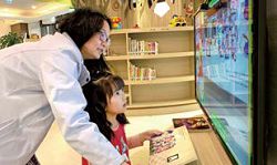 臺北市立圖書館親子美育數位圖書館AR 故事區透過擴增實境技術，可讓書中平面的圖像轉為3D 立體景觀。