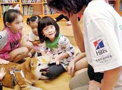 臺灣狗醫生協會的狗醫生，陪伴孩子閱讀。（新北市立圖書館新莊裕民分館提供）