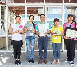 大安分館開發國寶植物「大安水蓑衣」系列文創,四位館員與黃欽輝主任(中)