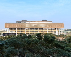 臺南市立圖書館新總館外觀，隱身樹林的淡金色格柵褶褶生輝
