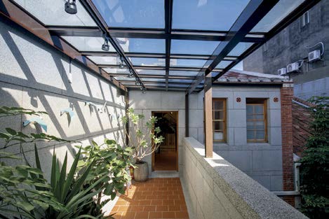 蔡瑞珊在採光充沛的天井搭建玻璃屋頂，打造一座可以遮風避雨的青鳥走廊。