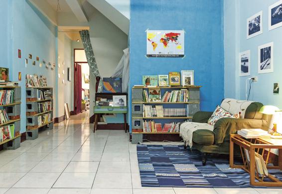 淺藍色壁面的2樓空間，貼著本多繁之的黑白攝影創作，舒適的單人沙發，自成一個溫馨閱讀角落。