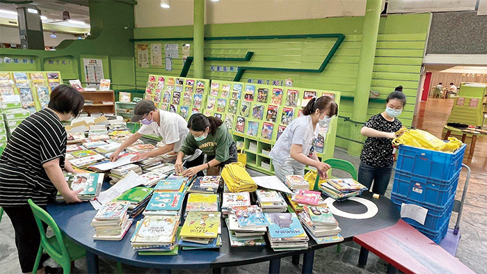宜蘭縣政府文化局圖書館裡，館員正忙碌準備「閱讀宜夏」圖書驚喜箱。