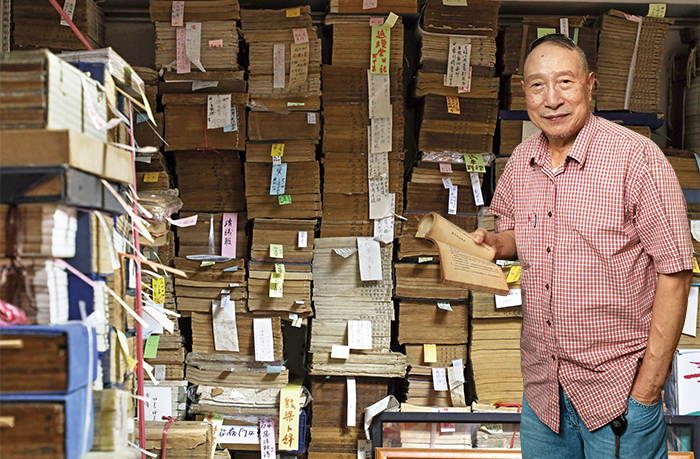 書店一隅的成疊老書冊，全是老老闆吳輝康一本本從世界各地扛回的典藏。