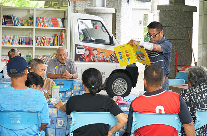 臺東縣文化處行動書車推出各項活動。圖為在地族語推廣老師為長輩進行書本導讀。