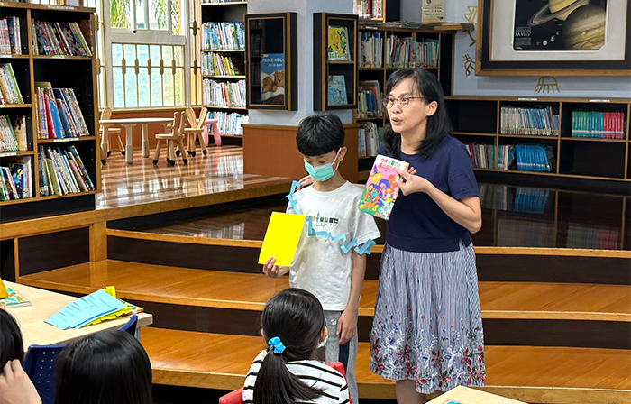 曾品方在圖書館進行閱讀教學，並邀請小朋友上台分享自己喜歡的書籍。