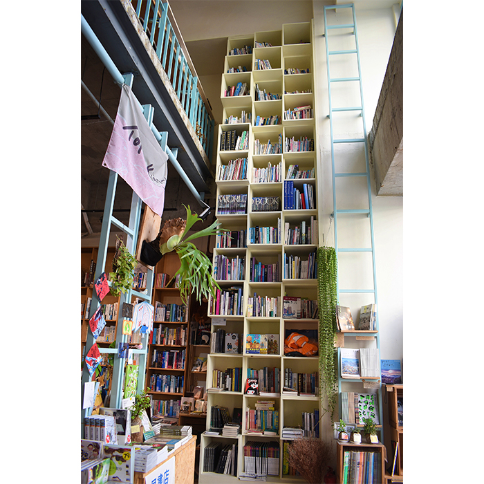 巨大的白色書櫃直接延伸至2樓，錯落的植栽為書店增添詩意。