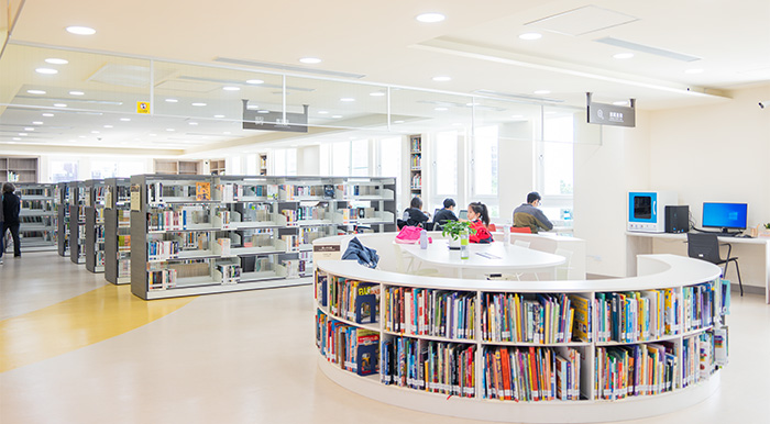 白色格柵書架呼應建築外觀，並且調整書架高度以利民眾取閱。