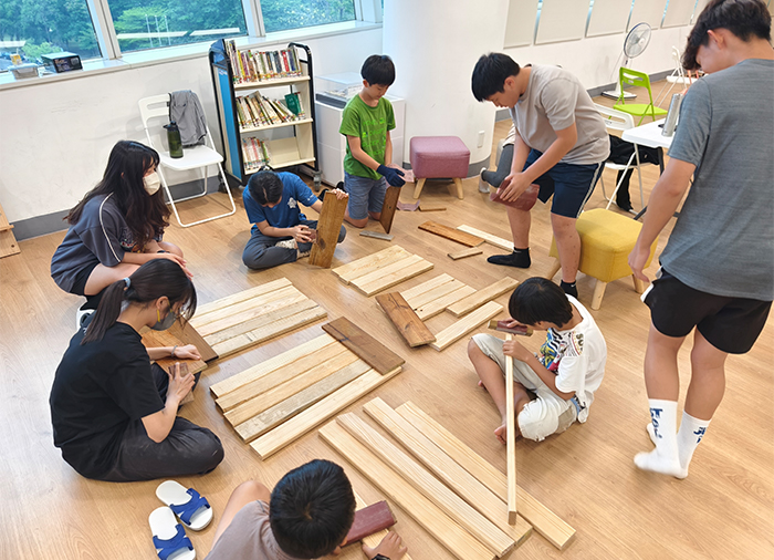 專業講師帶領青少年做木工,釘製「仿生高架菜箱」。