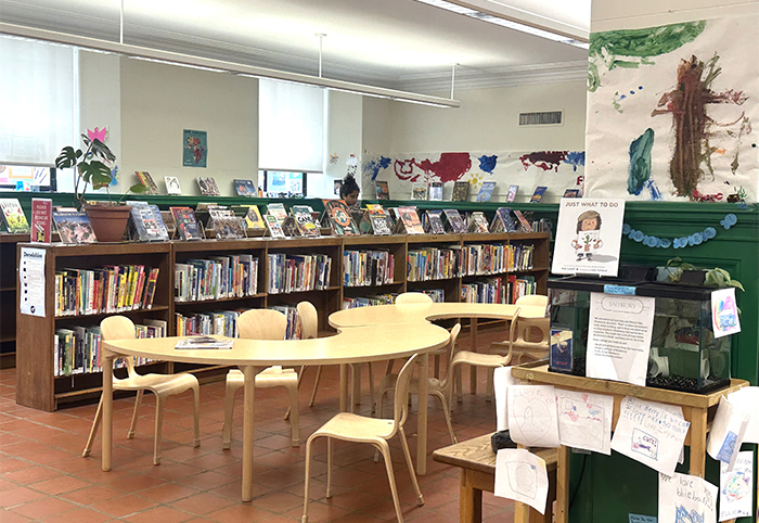 兒童區架上展示館員推薦的童書，柱子前的水族箱旁貼滿了紀念館魚的圖畫。