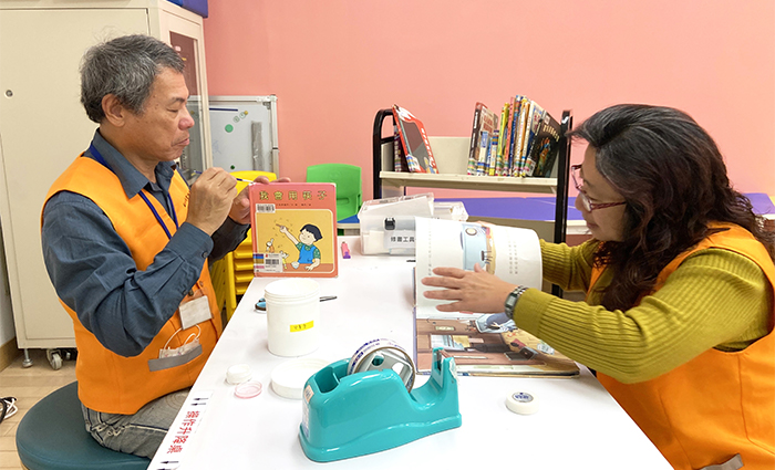 志工修補破損的兒童圖書。