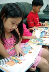 「讓書去旅行」活動中，學童津津有味地閱讀繪本。