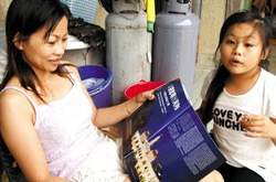 陳明玉看從圖書館借來的雜誌上越南報導，一解思鄉情緒。