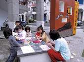 小朋友在三星鄉立圖書館前的大書本上做功課。