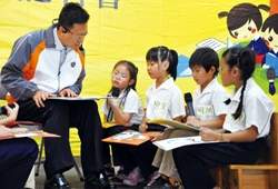 彰化縣長卓伯源(左)與學童齊說故事，宣傳世界書香日的活動。(彰化縣政府提供)