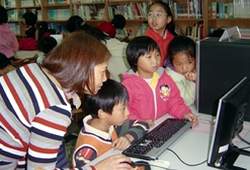 中正圖書館員指導兒童使用圖書資訊系統。