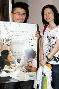 影迷拿導演簽名海報與鄭芬芬導演合影。