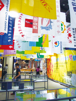 高雄勞工博物館開幕展仿英國曼徹斯特人民歷史博物館，展館處垂掛的大幅、色彩繽紛的工會旗幟。