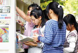 每當書車駛入學校,孩童們迫不及待翻閱書本,沉浸書香世界。