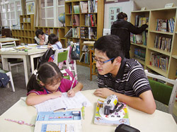 淡江大學資圖系學生協助鄧公國小弱勢學童做功課及閱讀陪伴。（淡江大學資圖系提供）