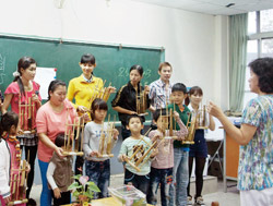 新住民與子女一起學習印尼樂器「安庫隆」。（臺灣東南亞姐妹會提供）