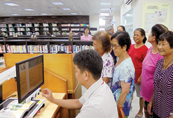 新北市立圖書館平溪分館運用「樂齡下午茶」活動,主動向長者介紹,館內專為銀髮讀者設置的「全彩擴視機」功能。(新北市立圖書館平溪分館提供)