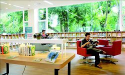 空間改造後的臺南市立圖書館總館強調自然採光及通透性，以大面玻璃引入公園綠意景觀。