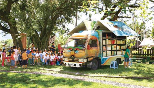 行動圖書館讓孩子可以在大樹下享受閱讀。( 富邦文教基金會提供)