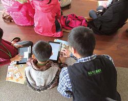 館員指導小朋友操作「台灣雲端書庫@ 高雄」。（高雄市立圖書館提供）