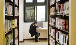 讀者於桃園市立圖書館中壢分館窗戶旁的位置，享受閱讀的愜意氛圍。