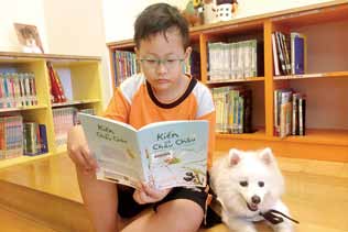 小朋友在寵物的陪伴之下開心閱讀。( 新北市立圖書館新莊裕民分館提供)